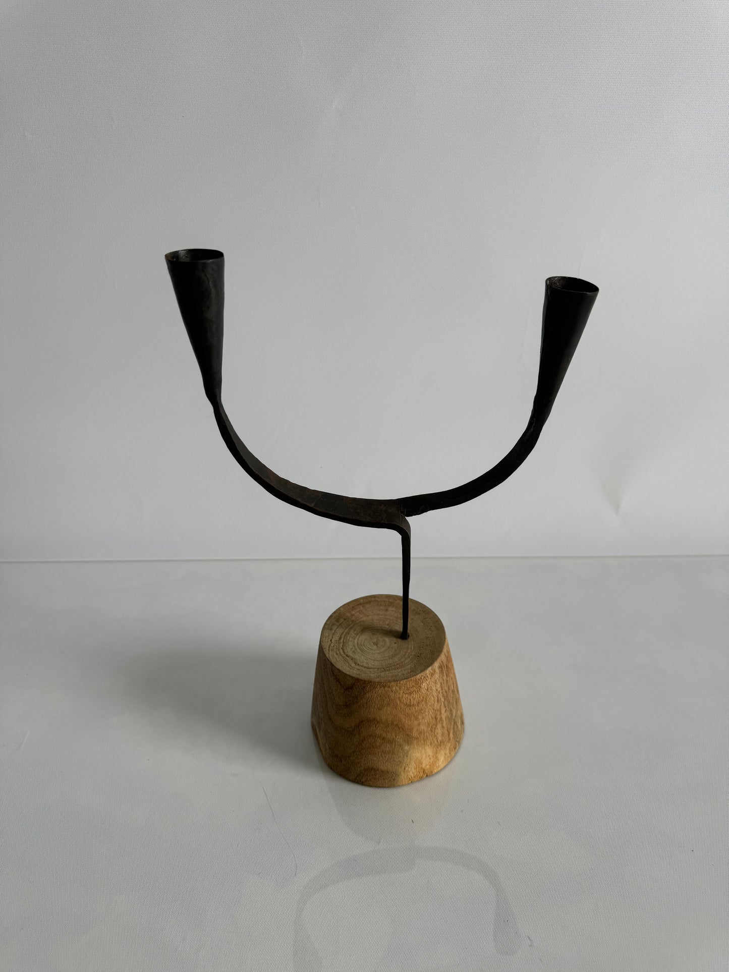 Forged metal taper candlestick holder on wood base