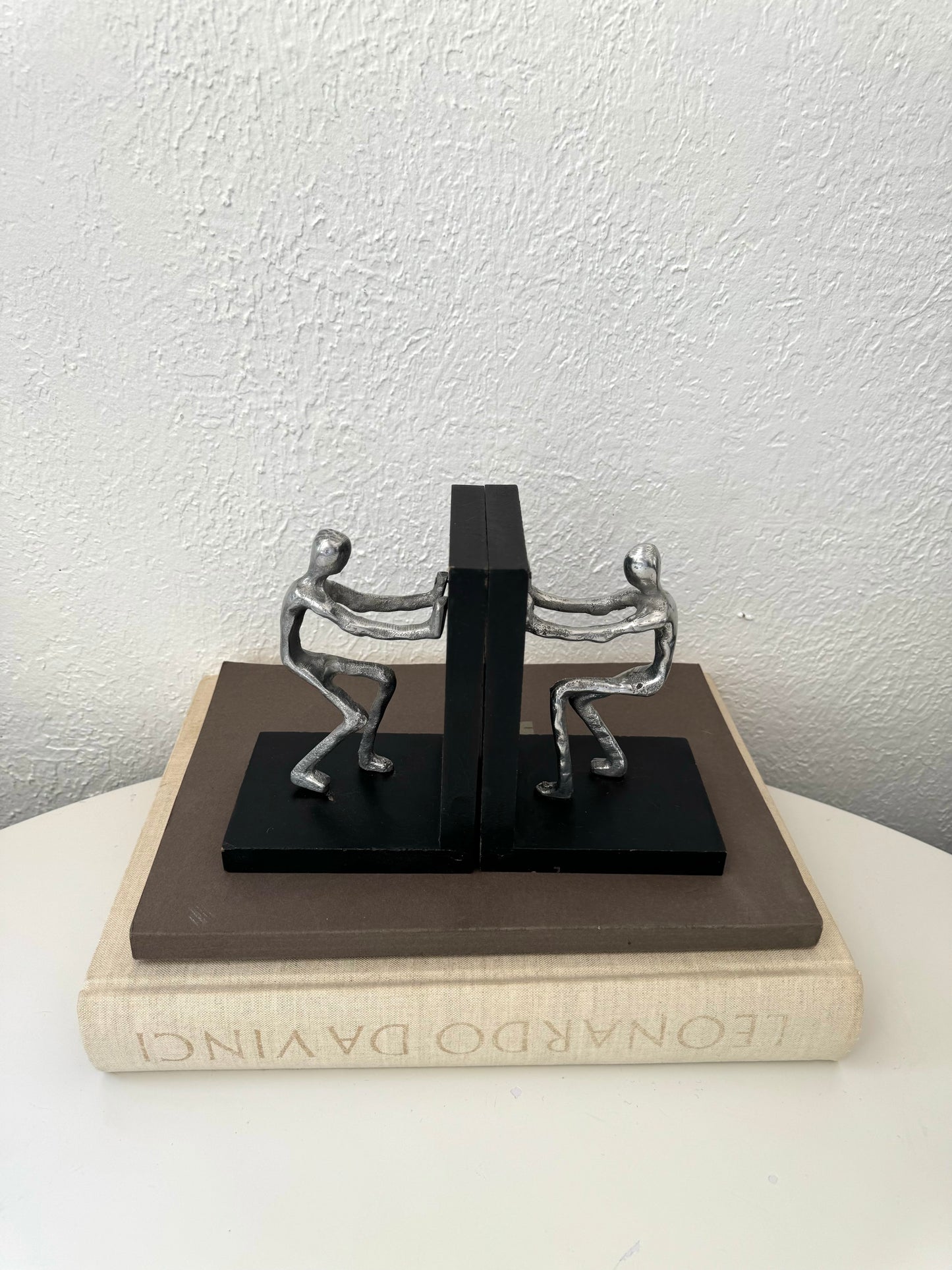 Silver metal men pushing sculpture bookends | Set of 2