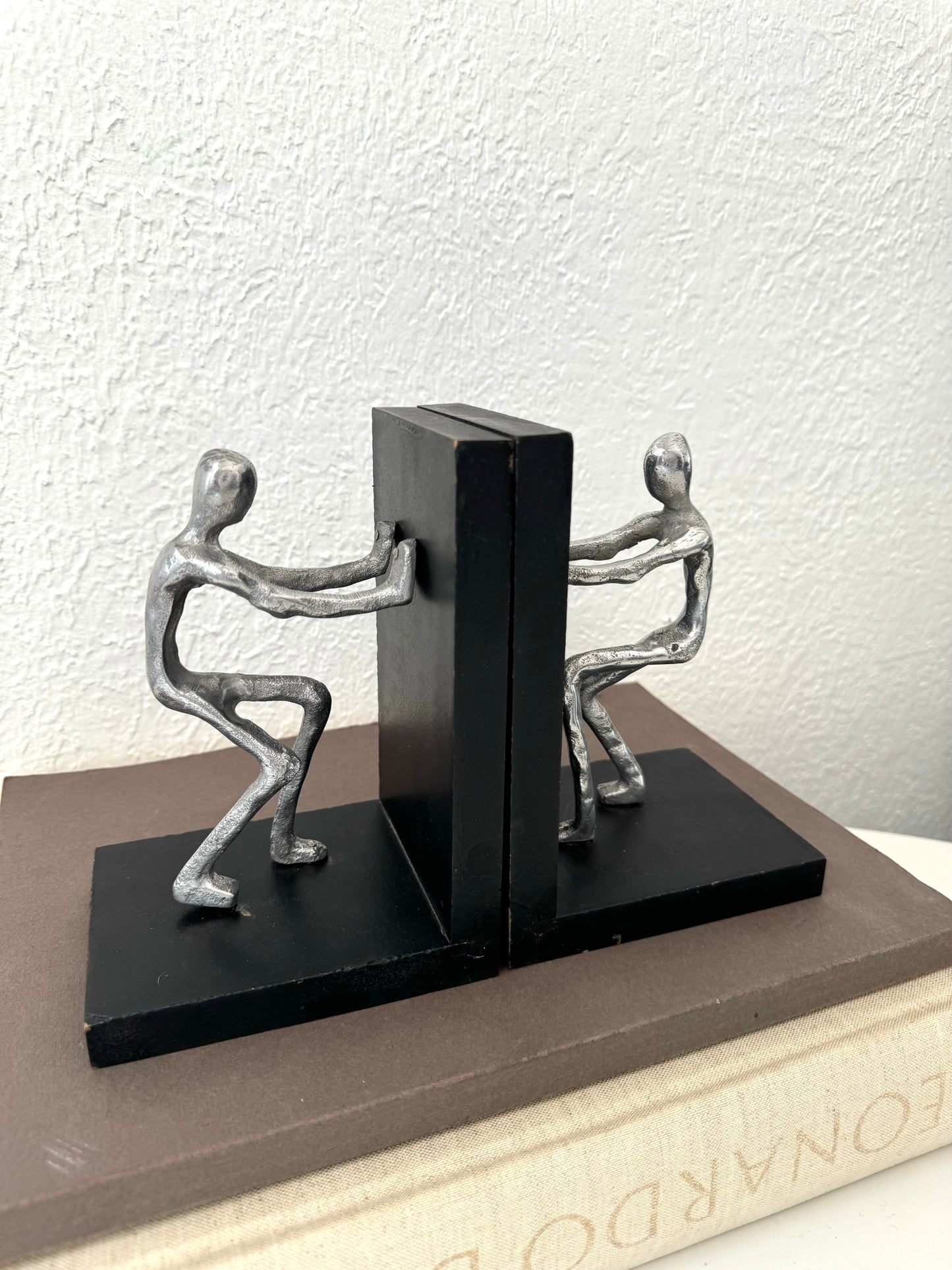 Silver metal men pushing sculpture bookends | Set of 2