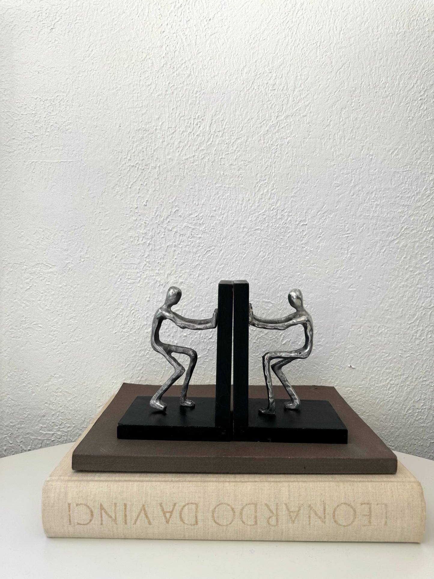 Silver metal men pushing sculpture bookends | Set of 2